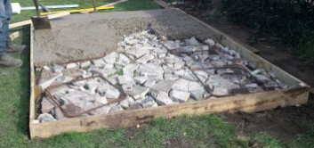 Part concreted base with broken stones under the concrete